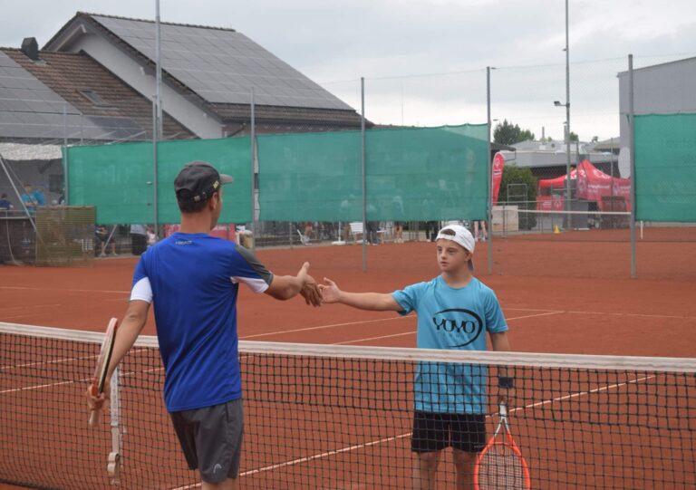 Zwei Tennisspieler klatschen sich die Hände.