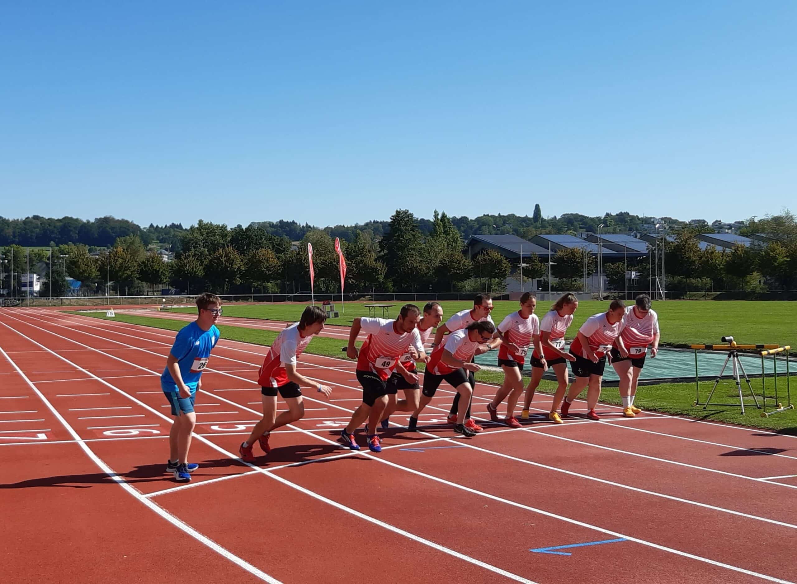 Corridori alla partenza su una pista di atletica soleggiata