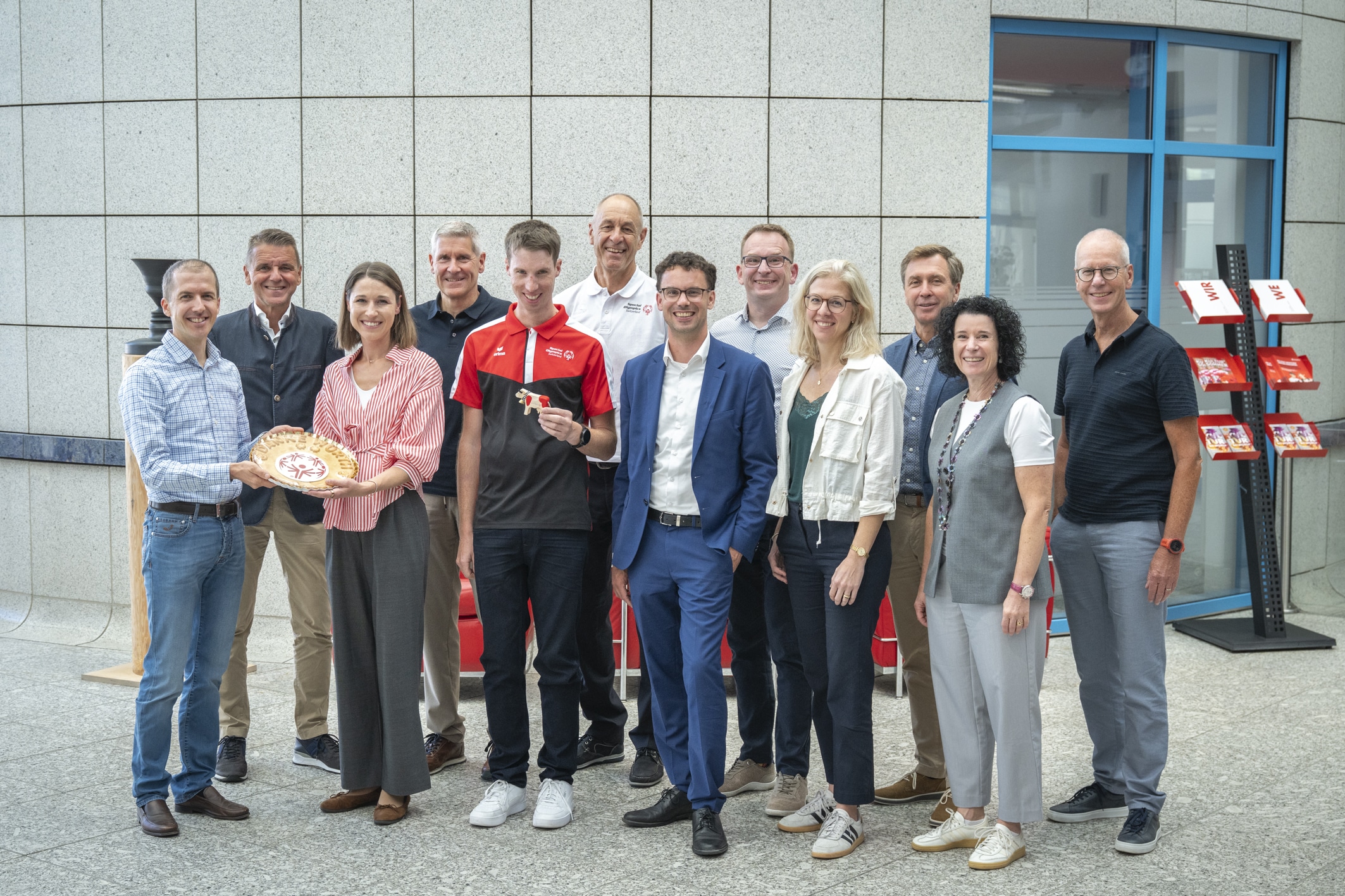 Il gruppo presenta una torta con il logo di Special Olympics nell’area d’ingresso