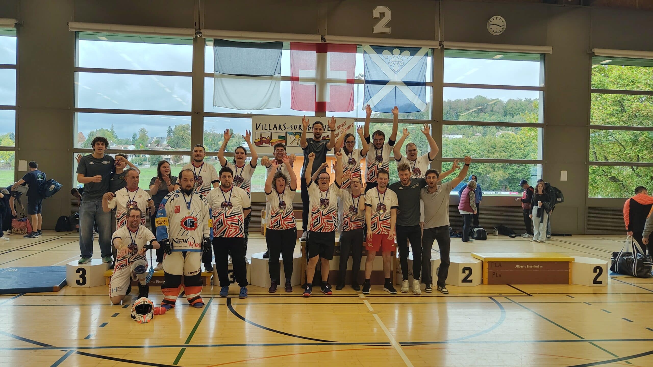Squadra di floorball esulta sul podio dei vincitori in palestra