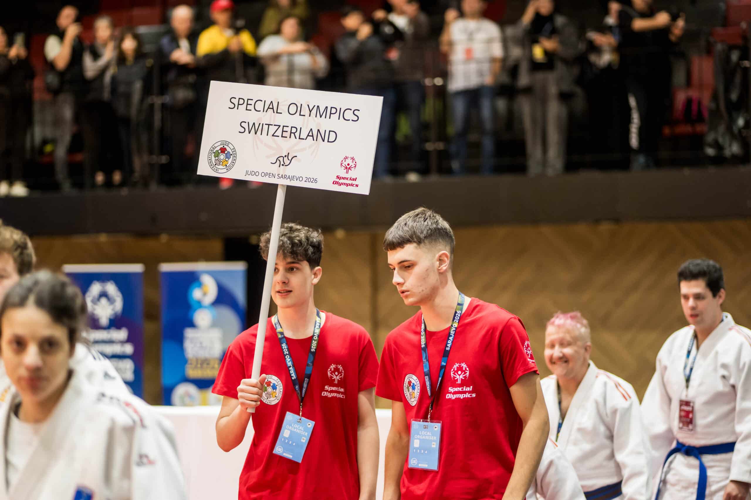 Giovani con cartello “Special Olympics Switzerland” in palestra